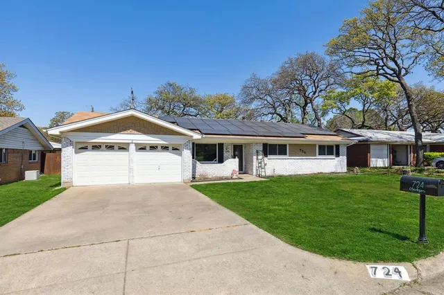 a front view of a house with a garden and trees