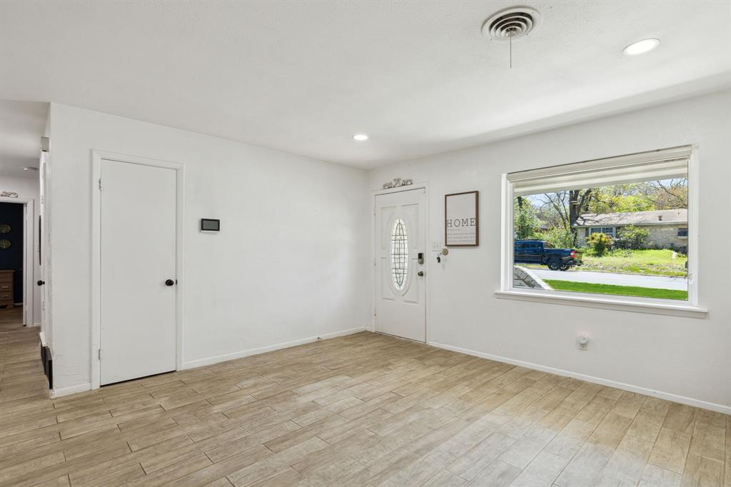 724 Edgehill Drive Hurst, TX 76053 - Photo 4 of 27 wooden floor in an empty room with a window