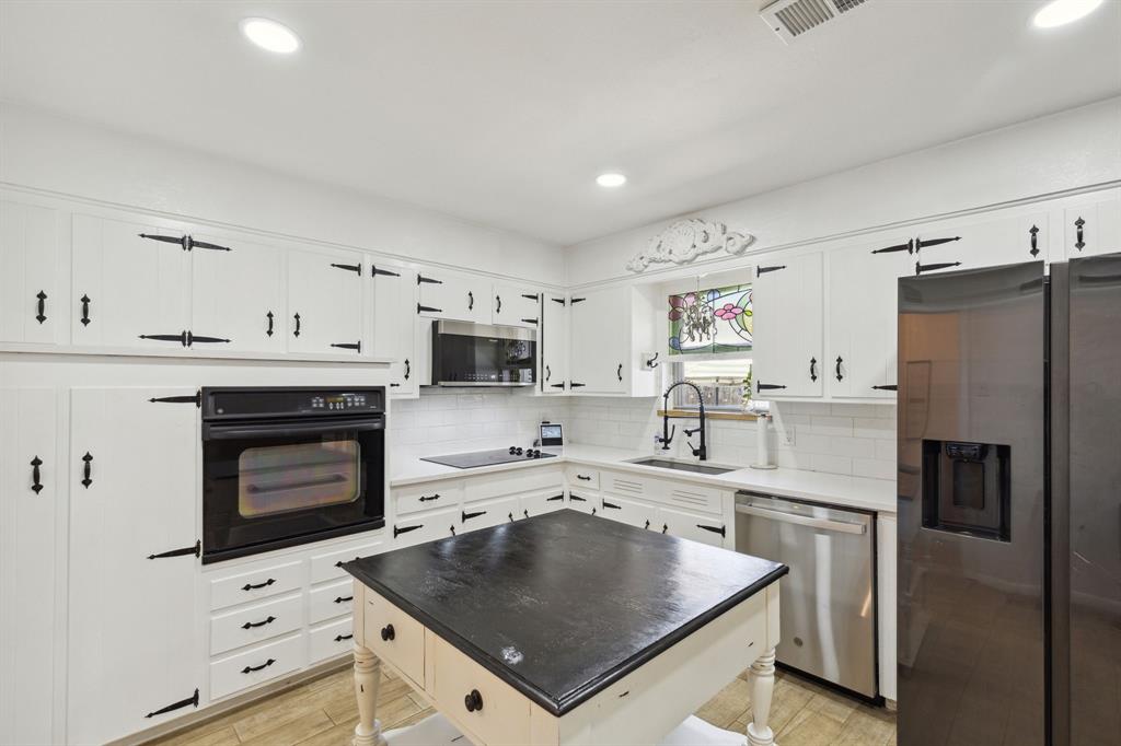 724 Edgehill Drive Hurst, TX 76053 - Photo 10 of 27 a kitchen with stainless steel appliances a stove sink and refrigerator