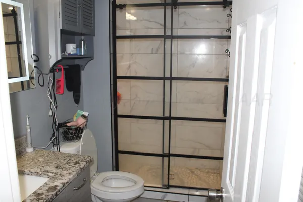 a bathroom with a granite countertop sink and a mirror