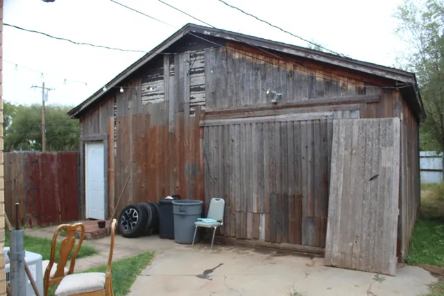 a backyard of a house with chairs and a table