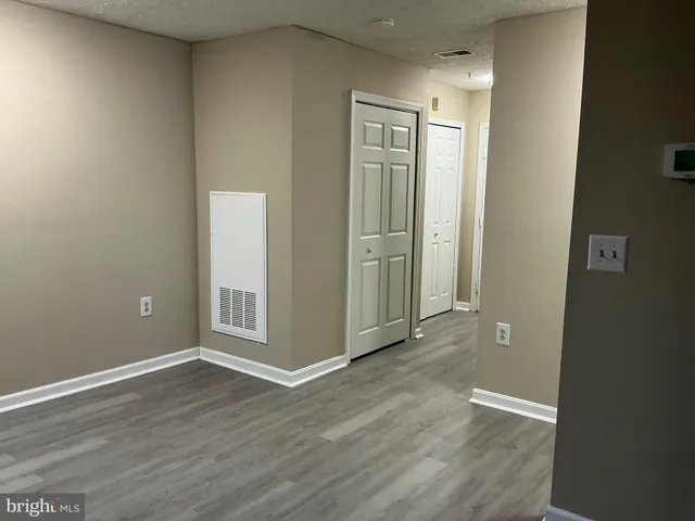 an empty room with wooden floor and closet