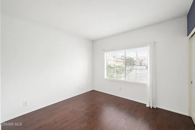 an empty room with wooden floor and a window
