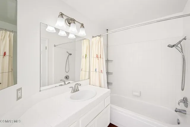 a bathroom with a bathtub a sink and a mirror