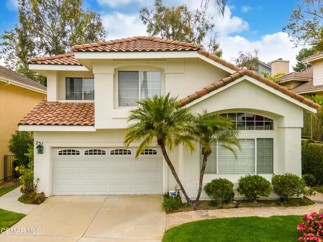 a view of a house with a yard and potted plants