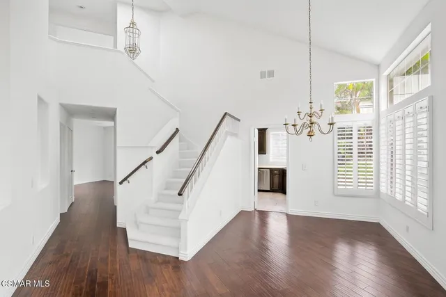 a view of a livingroom with wooden floor and stairs