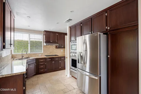 a kitchen with stainless steel appliances granite countertop a refrigerator and a sink
