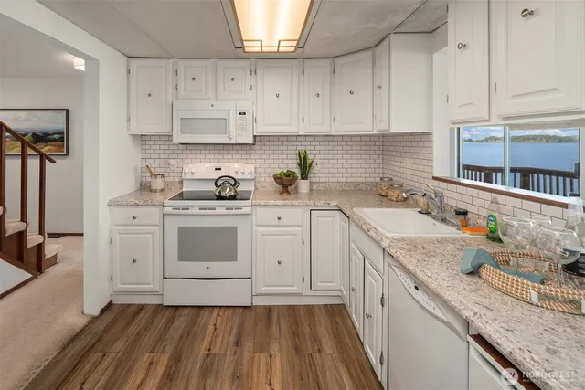 a kitchen with granite countertop a sink stove and cabinets