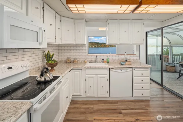 a kitchen with white cabinets and white appliances