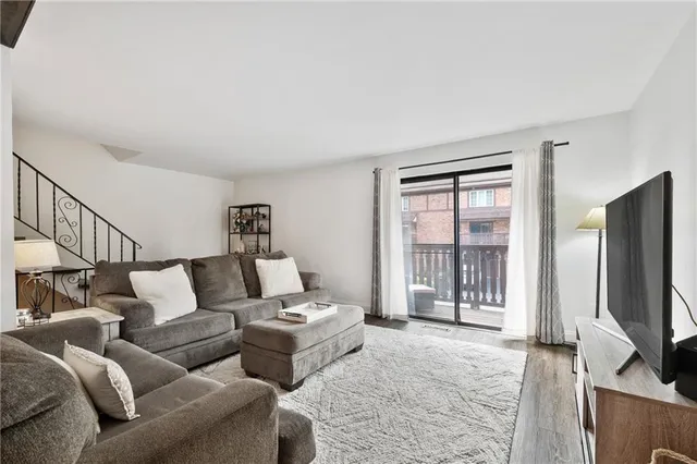 a living room with furniture a flat screen tv and a window