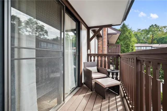 a balcony with wooden floor table and chairs