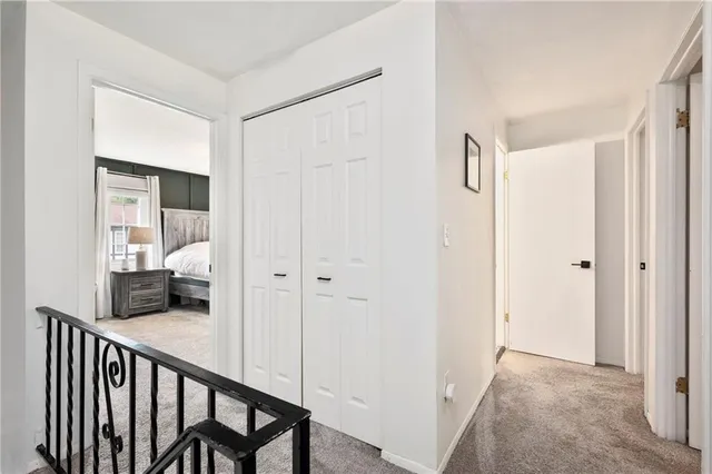 a view of a hallway to a livingroom with furniture and stairs