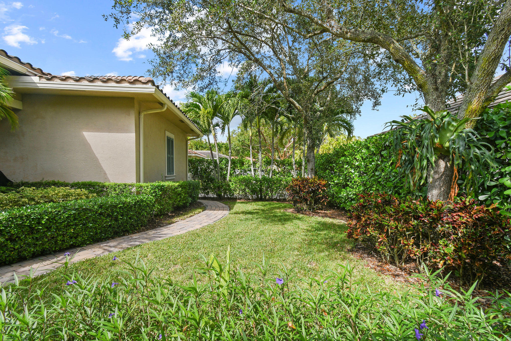 167 Arklow Avenue Jupiter, FL 33458 - Photo 44 of 60 a yellow house with flower garden in front of it