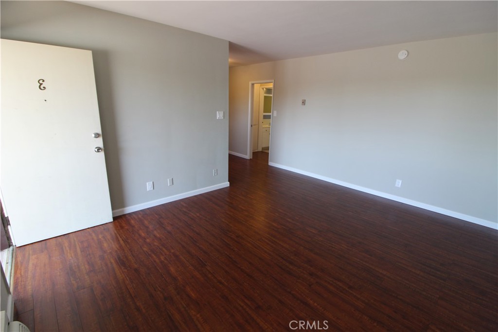 5853 Greenleaf Avenue, Unit E Whittier, CA 90601 - Photo 1 of 10 a view of an empty room with wooden floor and a window