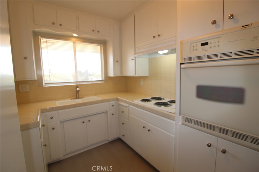 5853 Greenleaf Avenue, Unit E Whittier, CA 90601 - Photo 4 of 10 a kitchen with a sink stove and cabinets