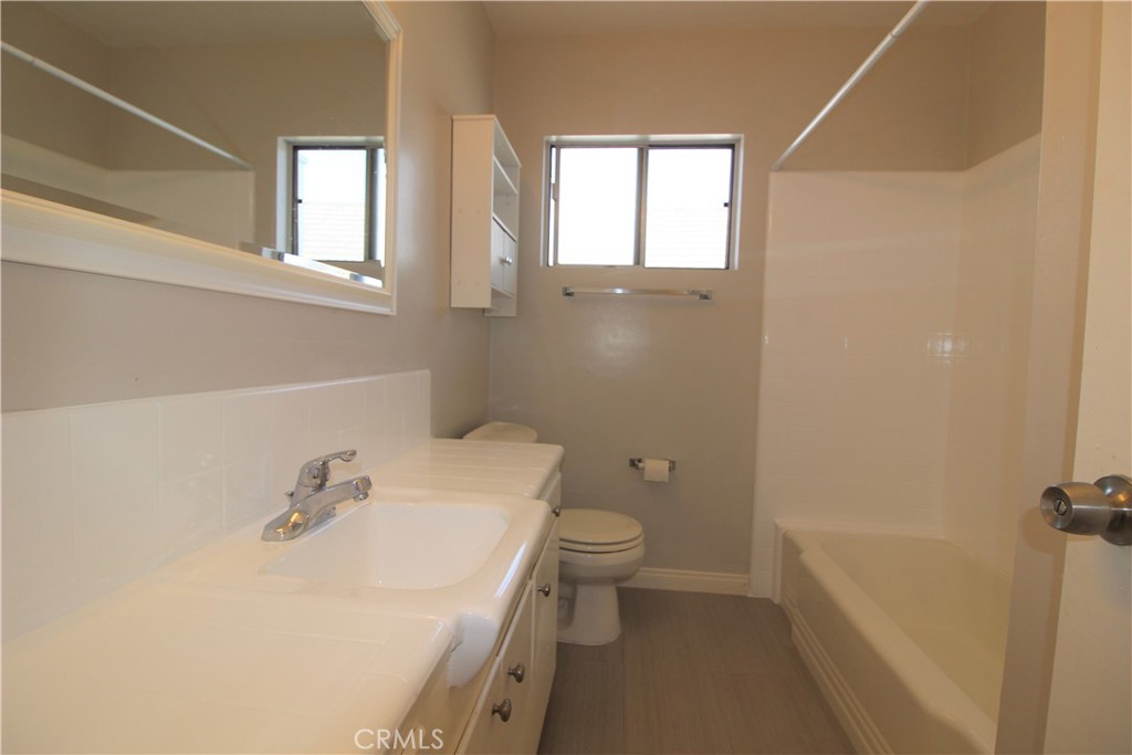 5853 Greenleaf Avenue, Unit E Whittier, CA 90601 - Photo 8 of 10 a bathroom with a sink a toilet and tub