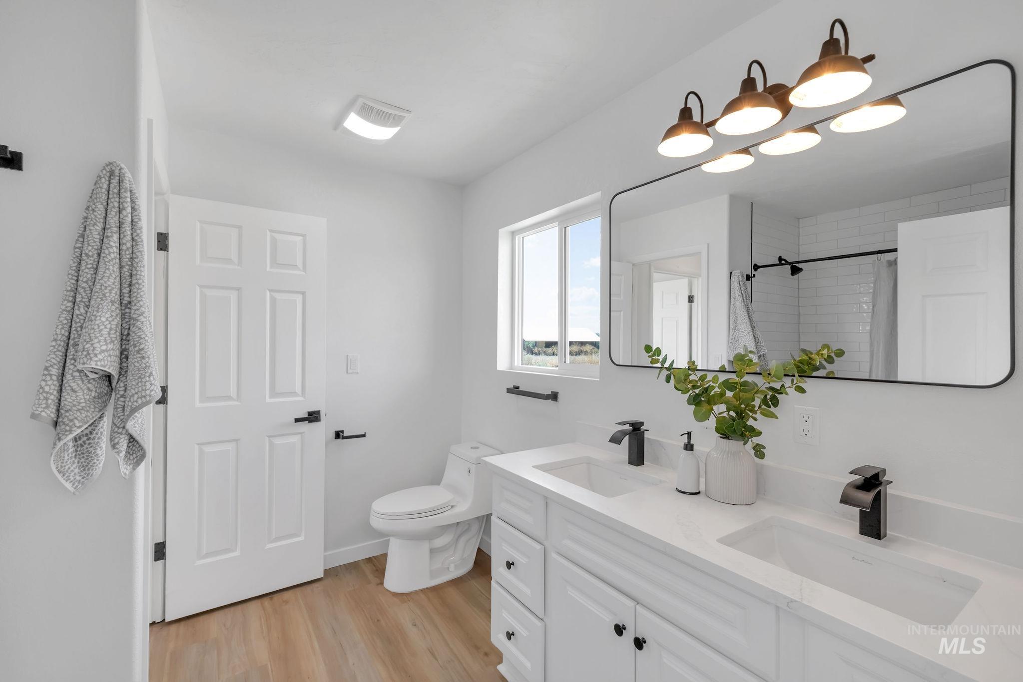 1070 West Indian Valley Road Indian Valley, ID 83632 - Photo 31 of 50 Bathroom featuring wood finished floors, double vanity, and tiled shower