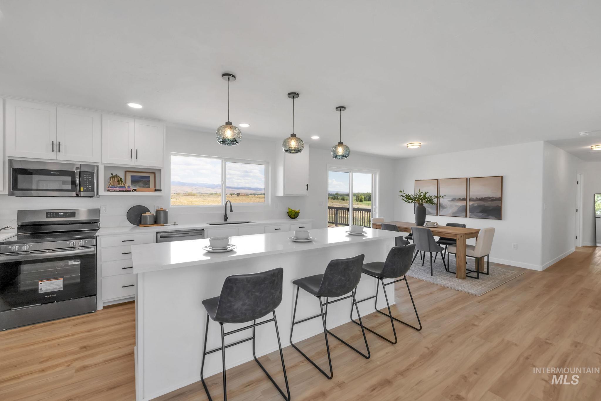 1070 West Indian Valley Road Indian Valley, ID 83632 - Photo 10 of 50 Kitchen featuring appliances with stainless steel finishes, a breakfast bar, light countertops, white cabinetry, and recessed lighting