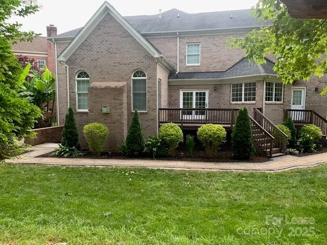 a view of a house with a big yard and large trees
