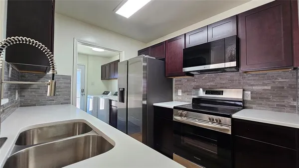 a kitchen with a sink cabinets and wooden floor