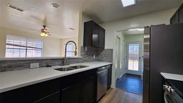 a kitchen with stainless steel appliances and wood cabinets