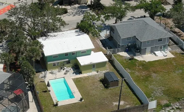 an aerial view of a house with a yard and furniture