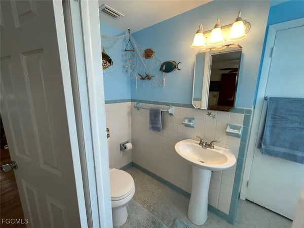 a bathroom with a sink toilet and mirror