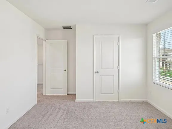 an empty room with windows and closet