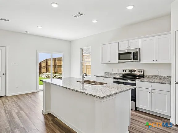152 Mullen Taylor, TX 76574 - Photo 4 of 20 a kitchen with a sink stove and microwave