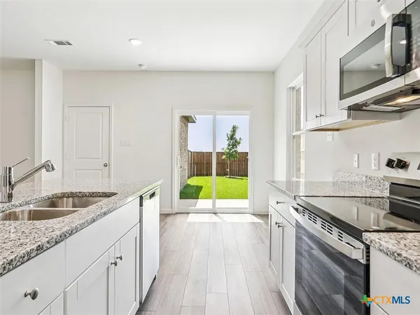 a kitchen with a sink stove and cabinets