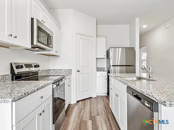 a kitchen with stainless steel appliances granite countertop a refrigerator stove and sink
