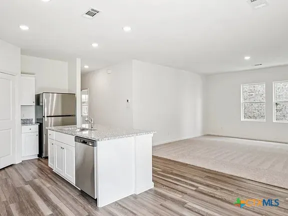 a kitchen with stainless steel appliances a refrigerator sink and microwave