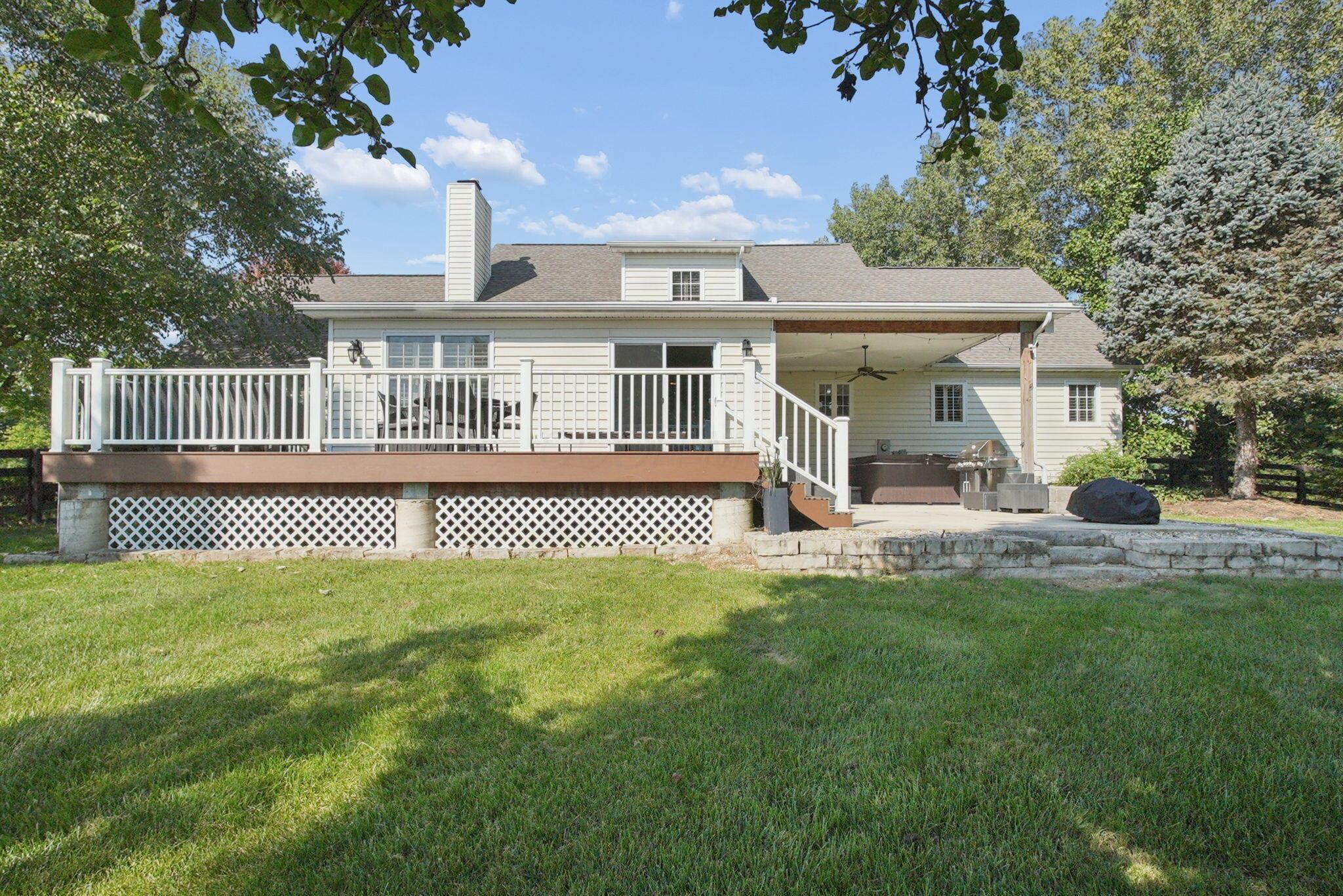 9435 Concord Road Powell, OH 43065 - Photo 59 of 77 Rear exterior featuring a multi-level deck, covered patio, and stone retaining wall