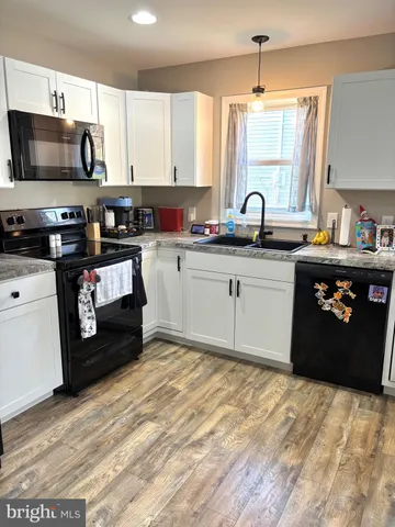 a kitchen with stainless steel appliances granite countertop a stove a sink dishwasher and a microwave oven with cabinets