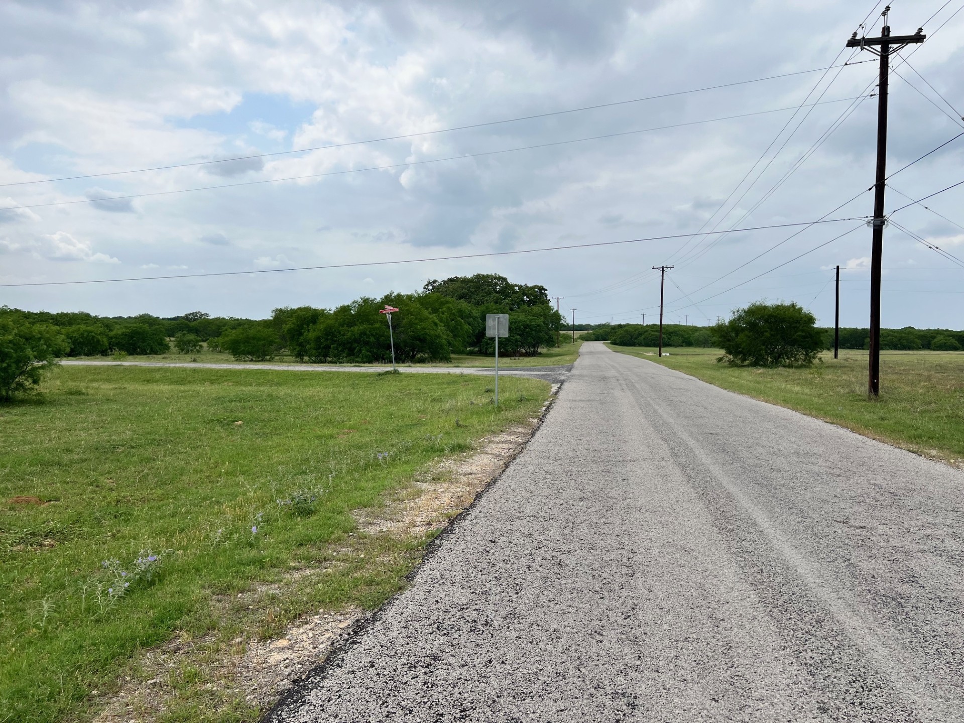 Lot 17 Settlement Way Luling, TX 78648 - Photo 9 of 14 A tranquil, tree-lined road stretches into the distance, offering a serene rural escape.
