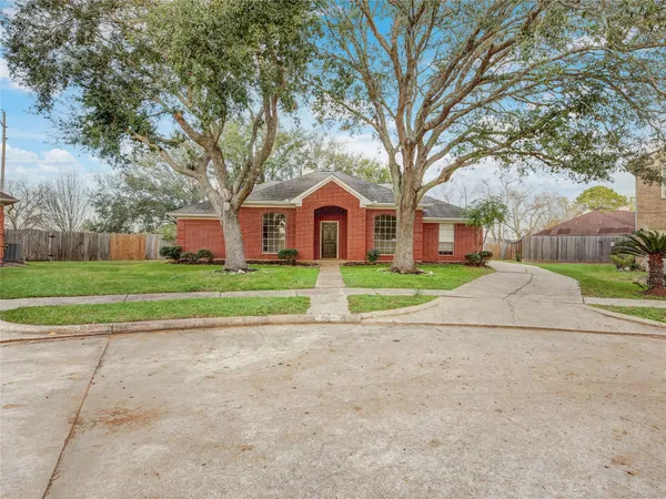 a view of a house with a big yard and large trees