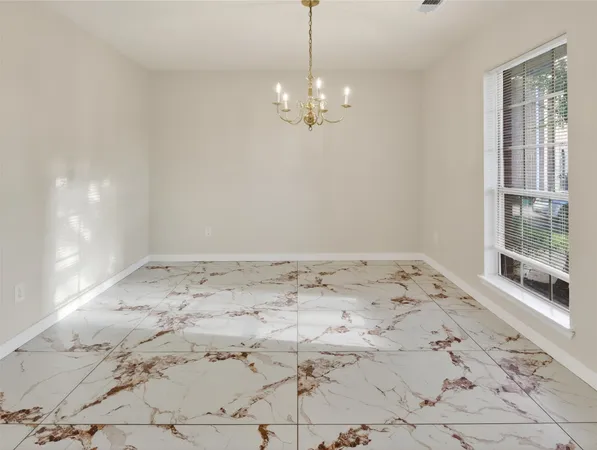 a view of a big room with wooden floor and windows
