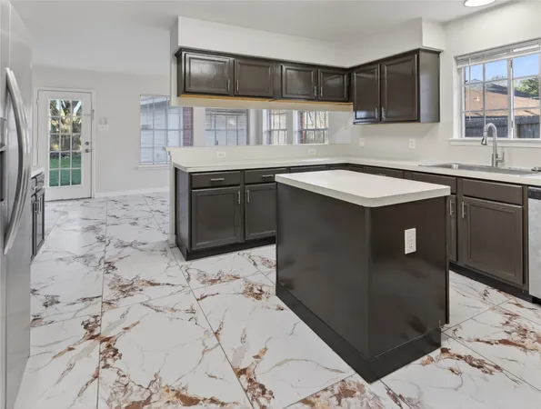 a kitchen with stainless steel appliances kitchen island sink refrigerator and microwave