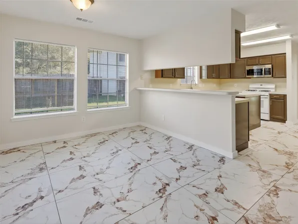 a view of kitchen with wooden floor and cabinets
