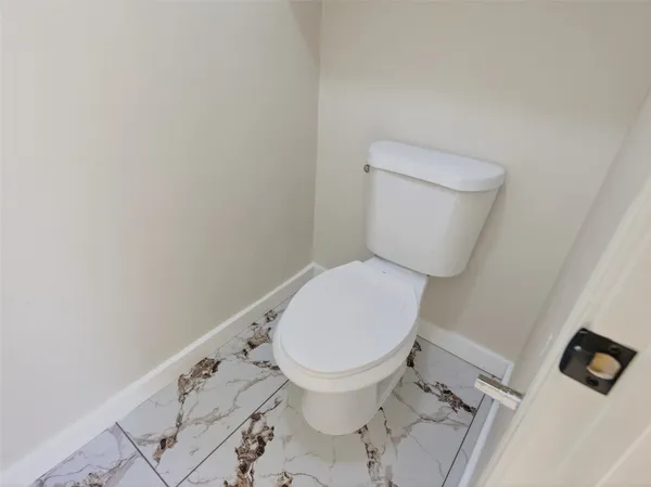 a white toilet sitting next to a white sink and vanity