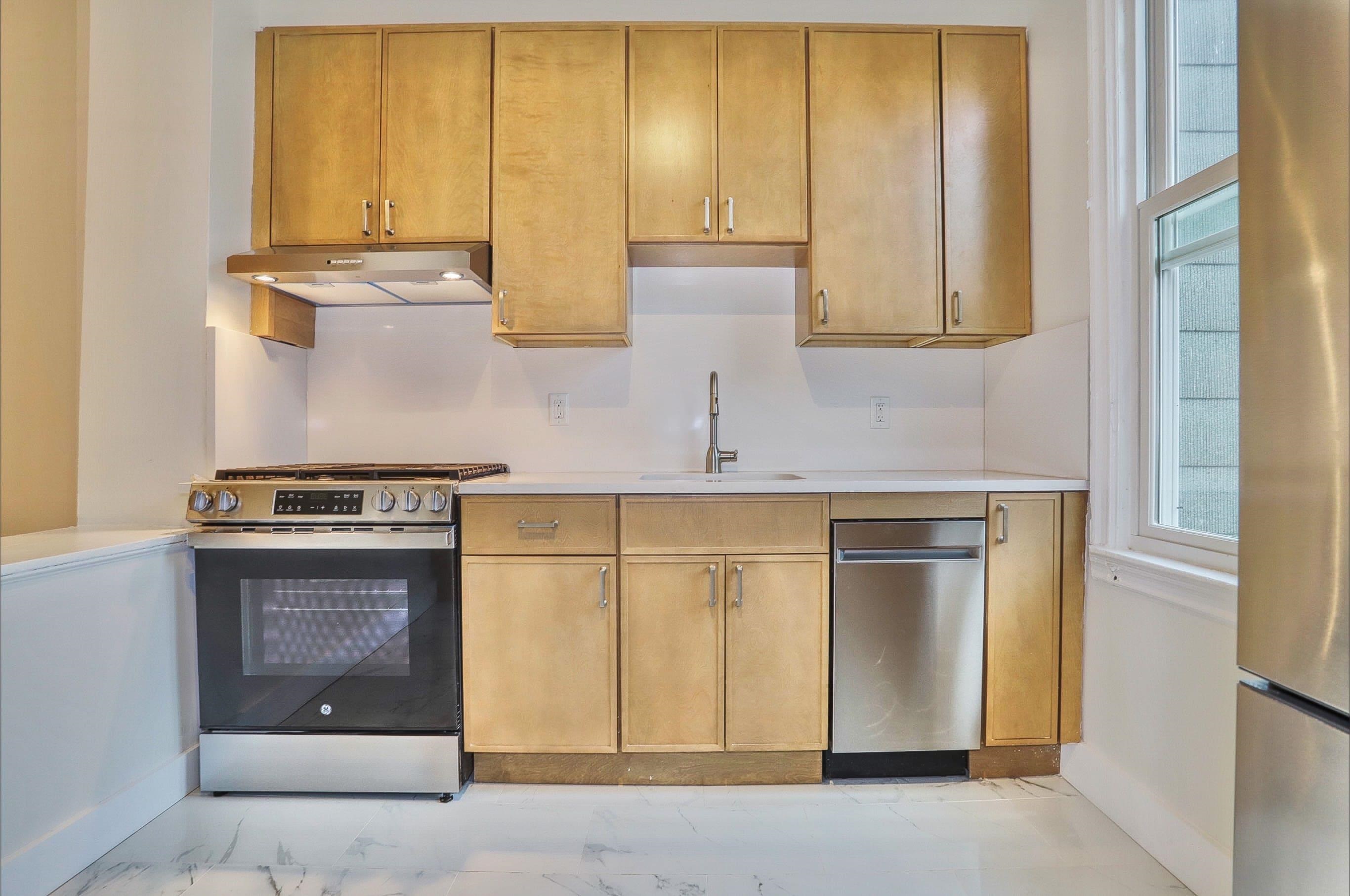 232 Garden Street, Unit 2 Hoboken, NJ 07030 - Photo 5 of 24 a kitchen with stainless steel appliances granite countertop a stove and a refrigerator