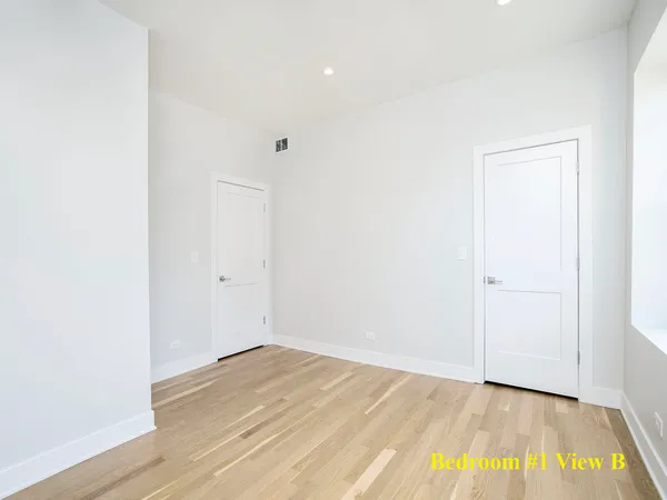 a view of a room with wooden floor and white walls