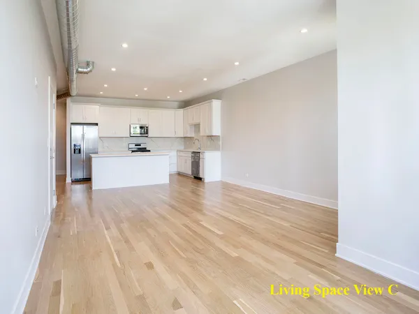 a open kitchen with white cabinets and wooden floor