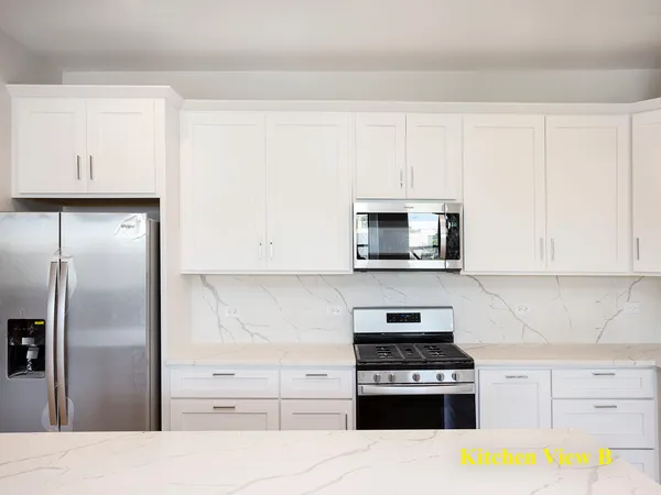 a kitchen with stainless steel appliances granite countertop a refrigerator stove and sink