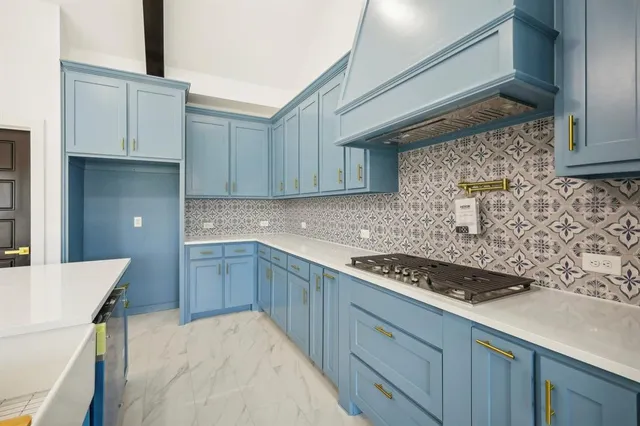 a kitchen with stainless steel appliances granite countertop a stove a sink and a white cabinets