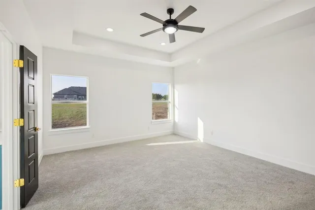 an empty room with fan and windows