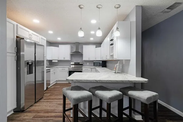 a large kitchen with a table and chairs