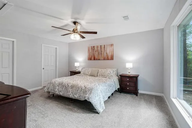 a bedroom with a bed and a ceiling fan