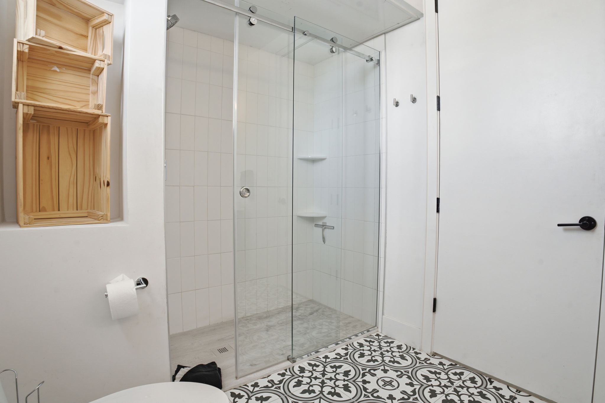 2709 East 5th Street, Unit 1306 Austin, TX 78702 - Photo 13 of 28 A sleek, contemporary bathroom features a clear glass shower enclosure and a distinctive patterned tile floor.