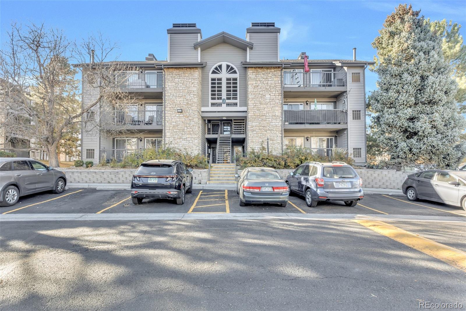 2575 South Syracuse Way, Unit J108 Denver, CO 80231 - Photo 1 of 18 a view of a cars parked in front of a building